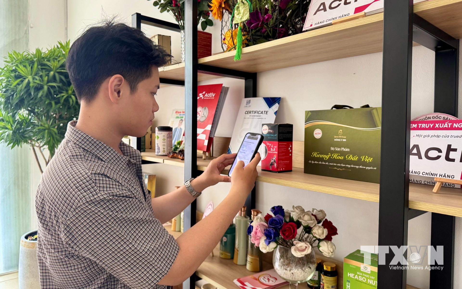 Người dân TP. Hồ Chí Minh quét mã sản phẩm, tìm hiểu thông tin nguồn gốc xuất xứ, tại khu trưng bày hàng hóa của Công ty Cổ phần Công nghệ Chống giả Việt Nam. (Ảnh: Hương Giang/TTXVN)
